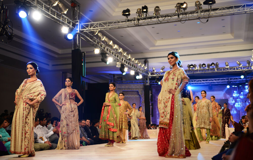 Models posing in traditional clothes during a catwalk on the ramp